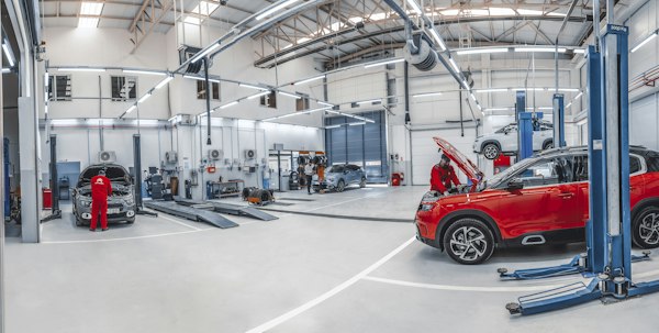A bright, spacious auto repair workshop with mechanics working on cars