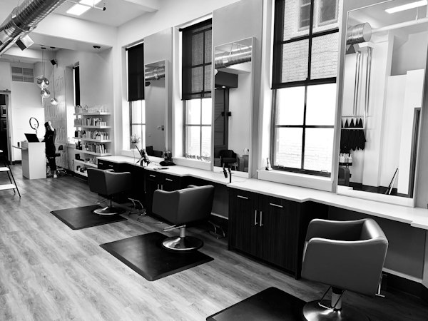 A hair salon with styling chairs and mirrors